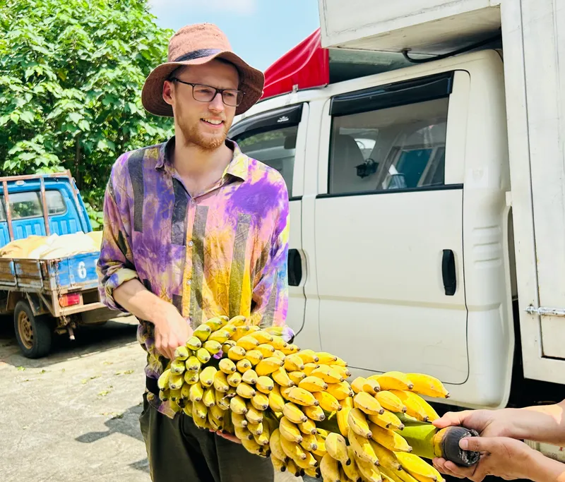Jannes holding some bananas and smiling